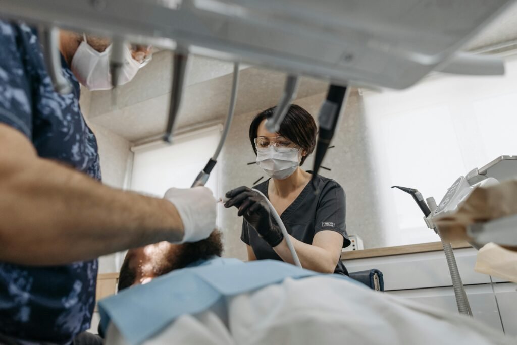Two dentists performing a dental procedure on a patient in a modern clinic environment.